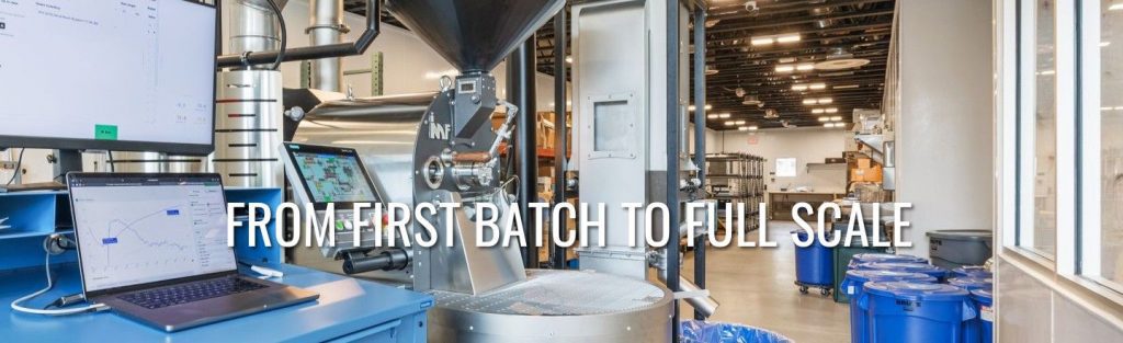 Roaster workstation with IMF drum roaster, roast curve on laptop screen, and open production floor in the background.