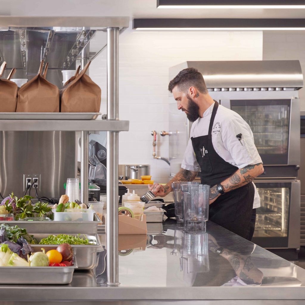 Chef preparing fresh food in commercial kitchen at Postscript coffee and dining concept, San Francisco, CA